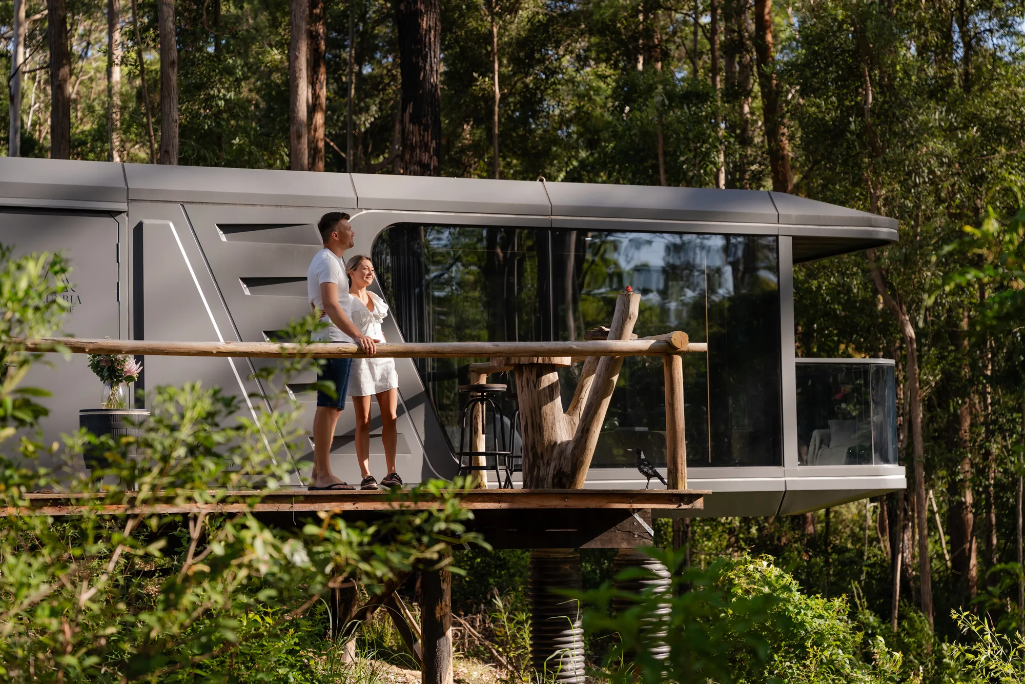 Couple on elevated cabin deck in forest